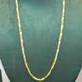A gold chain necklace displayed on a dark green velvet jewelry bust against a plain light background.