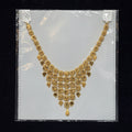 Gold necklace on a clear plastic bag with a black background