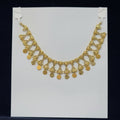 Gold necklace on a white card with a black background