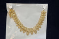 Gold necklace on a clear plastic bag with a black background