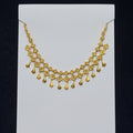 Gold necklace on a clear plastic bag with a black background